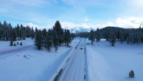 2020---vista-aérea-of-cars-conduciendo-slowly-on-icy-snow-covered-montaña-road-in-the-Eastern-Sierra-Nevada-montañas-near-Mammoth-California