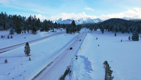 2020---aerial-of-cars-driving-slowly-on-icy-snow-covered-mountain-road-in-the-Eastern-Sierra-Nevada-mountains-near-Mammoth-California-1