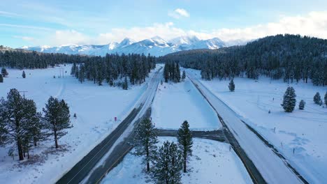 2020---aerial-of-cars-driving-slowly-on-icy-snow-covered-mountain-road-in-the-Eastern-Sierra-Nevada-mountains-near-Mammoth-California-2