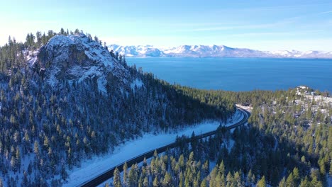 2020--beautiful-aerial-of-Highway-50-approaching-Lake-Tahoe-in-snow-and-winter-with-traffic-on-highway-below