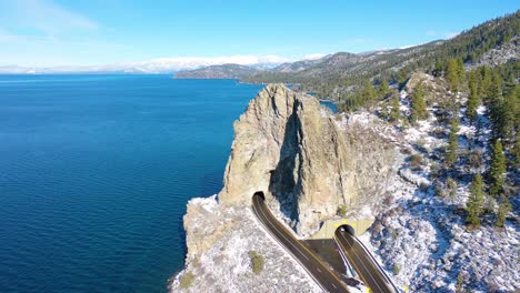 2020--winter-snow-aerial-Cave-Rock-tunnel-along-the-eastern-shore-of-Lake-Tahoe-Nevada-with-road-and-traffic-below-1