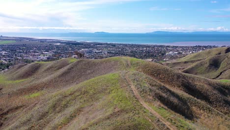 2020:-Vista-Aérea-Sobre-Las-Verdes-Colinas-Y-Montañas-De-La-Costa-Del-Pacífico-Detrás-De-Ventura-California,-Incluidas-Las-Casas-Y-Los-Vecindarios-Suburbanos