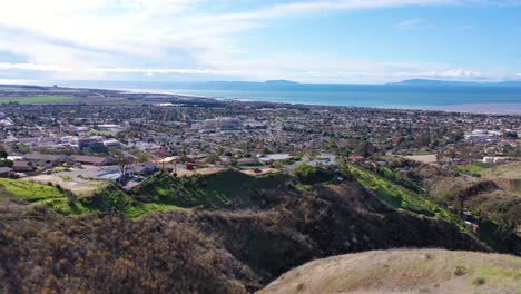 2020---aerial-over-the-pacific-coastal-green-hills-and-mountains-behind-Ventura-California-including-suburban-homes-and-neighborhoods-1
