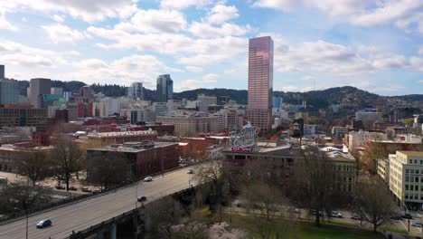 Aerial-reveals-Portland-Oregon-stag-deer-sign-and-downtown-old-town-cityscape-and-business-district