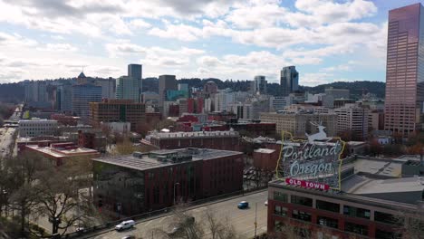 Aerial-past-Portland-Oregon-stag-deer-sign-and-downtown-old-town-cityscape-and-business-district