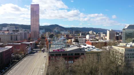 Aerial-past-Portland-Oregon-stag-deer-sign-and-downtown-old-town-cityscape-and-business-district-1