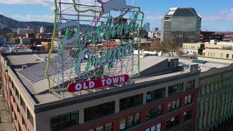 Rising-aerial-reveals-Portland-Oregon-stag-deer-sign-and-downtown-cityscape-and-business-district-1