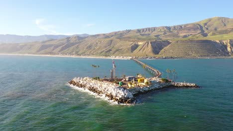 Vista-Aérea-over-a-long-oil-pier-extending-to-a-small-island-off-the-shore-of-Mussel-Shoals-Rincon-Beach-Santa-Barbara-California-3