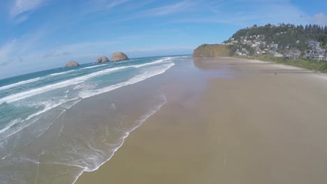 An-aerial-image-rising-up-over-a-beautiful-beach-in-Oregon-with-waves-crashing