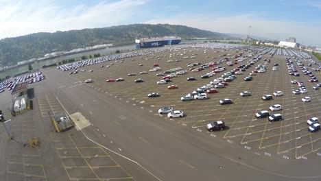 Eine-Antenne-über-Riesige,-Meist-Leere-Parkplätze-An-Einem-Containerhafen,-Der-Autos-Importiert-1