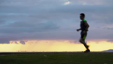 Man-runs-through-frame-sunset-scene-at-Ala-Moana-Beach-Park-in-Honolulu-Hawaii