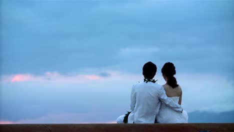 Wedding-couple-watches-sunset-at-Ala-Moana-Beach-Park-in-Honolulu-Hawaii