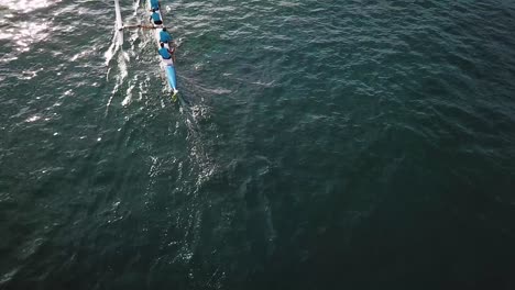 Beautiful-aerial-over-an-outrigger-canoe-paddled-on-blue-water