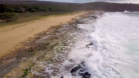 Aerial-over-a-couple-dancing-and-playing-on-a-long-beach-in-Molokai-Hawaii