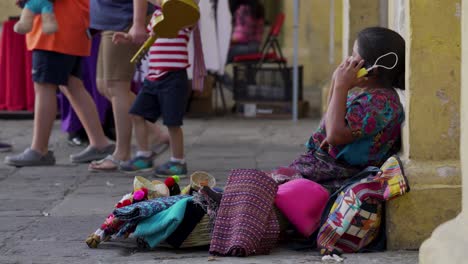 Una-Mujer-Guatemalteca-Habla-Por-Un-Teléfono-Celular-En-Una-Calle-Muy-Transitada