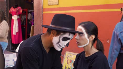 Un-Hombre-Pinta-El-Rostro-De-Una-Mujer-Para-El-Día-De-Los-Muertos-En-San-Miguel-De-Allende,-México.