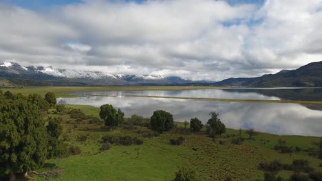 Beautiful-aerial-of-Andes-mountains-a-lake-and-pasture-land-near-Los-Alerces-National-Park