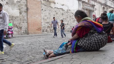 Eine-ältere-Maya-Frau-Vertreibt-Sich-Die-Zeit-Auf-Der-Straße-In-Antigua-Guatemala