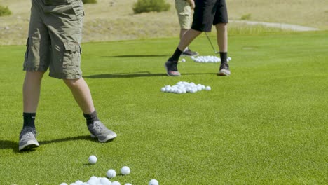 Three-young-golfers-hitting-a-bucket-of-balls-at-the-Rock-Creek-Cattle-Co-driving-range