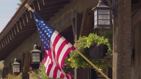 Eine-Amerikanische-Flagge,-Die-Außerhalb-Eines-Rustikalen-Schaufensters-In-Montana-Weht