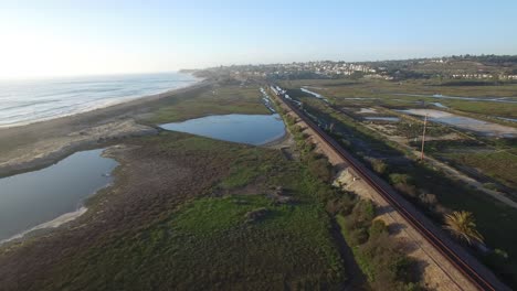 High-aerial-over-the-California-coastline-train-and-highway-near-San-Diego