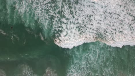 An-aerial-perspective-looking-straight-down-at-the-ocean-with-waves-rolling-in-1