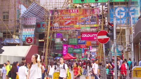 Pan-up-from-a-busy-commercial-district-in-Hong-Kong-China-to-reveal-workers-on-bamboo-scaffolding