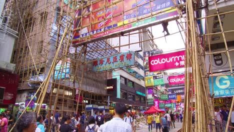 Pan-up-from-a-busy-commercial-district-in-Hong-Kong-China-to-reveal-workers-on-bamboo-scaffolding-1