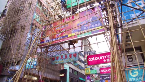 Pan-up-from-a-busy-commercial-district-in-Hong-Kong-China-to-reveal-workers-on-bamboo-scaffolding-2