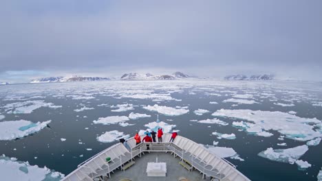 Una-Toma-De-Lapso-De-Tiempo-Pov-De-La-Proa-De-Un-Barco-Icebergs-Y-Turistas-Pasando-Por-Cape-Fanshaw-Alaska