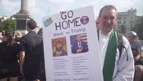 Ein-Priester-Hält-Ein-Schild,-Das-Donald-Trump-Während-Eines-Massenprotestes-Auf-Den-Straßen-Von-London-Mit-Jesus-Vergleicht,-Um-Gegen-Den-Besuch-Von-Uns-Präsident-Donald-Trump-Zu-Protestieren