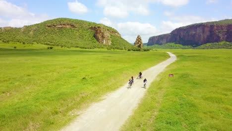 Aerial-of-a-group-of-four-bicyclists-riding-in-Hell's-Gate-National-park-Rift-Valley-Kenya-Africa