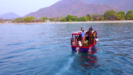 Antena-Sobre-Un-Pequeño-Barco-De-Buceo-Lleno-De-Turistas-Frente-A-La-Costa-De-Monkey-Bay-Malawi