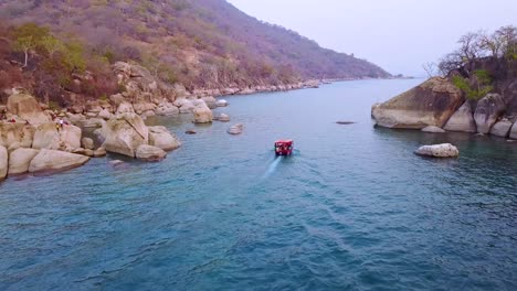 Antena-Sobre-Un-Pequeño-Barco-De-Buceo-Lleno-De-Turistas-Frente-A-La-Costa-De-Monkey-Bay-Malawi-1