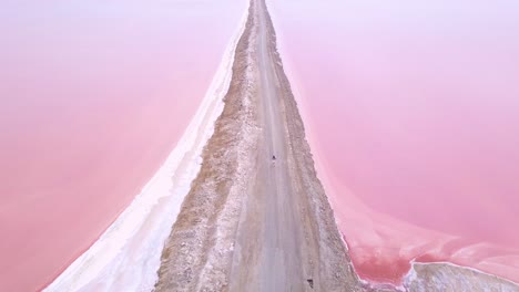 Amazing-aerial-over-a-woman-jogging-or-running-on-a-colorful-pink-salt-flat-region-in-Namibia-Africa