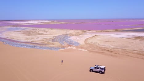 Amazing-aerial-over-a-woman-jogging-or-running-on-a-colorful-pink-salt-flat-region-in-Namibia-Africa-3