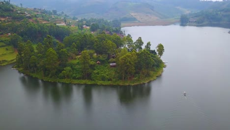 Antena-Sobre-Una-Lancha-Canoa-Lancha-Viajando-Por-Un-Lago-En-Una-Exuberante-Parte-De-Uganda,-África