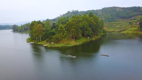 Aerial-over-a-motorboat-longboat-canoe-traveling-on-a-lake-in-a-lush-part-of-Uganda-Africa-1