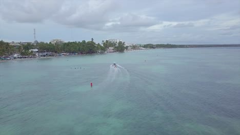 Antenne-über-Touristen,-Die-Ein-Bananenboot-Im-Strandviertel-Boca-Chica-In-Der-Dominikanischen-Republik-Fahren?