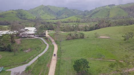Antenne-Eines-Fahrzeugs,-Das-Durch-Die-Kargen-Grünen-Landschaften-Der-Dominikanischen-Republik-Fährt