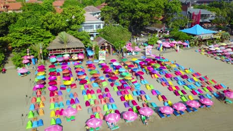 Antena-Sobre-Coloridas-Sombrillas-En-La-Playa-De-Sanur-O-Kuta,-En-La-Costa-De-Bali,-Indonesia-2