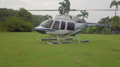 Move-around-aerial-of-a-Sandal's-resort-helicopter-sitting-on-a-grassy-open-space-on-a-luxurious-tropical-island-in-Jamaica