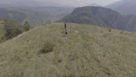 Antena-De-Gente-Caminando-En-La-Cima-De-Una-Colina-Cerca-De-La-Aldea-De-Lukomir-En-Bosnia,-Antigua-Yugoslavia