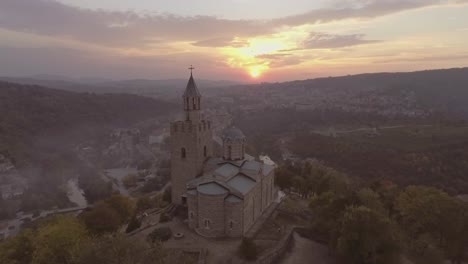 Very-pretty-aerial-of-a-majestic-ancient-stone-cathedral-or-church-in-Bulgaria-at-sunset