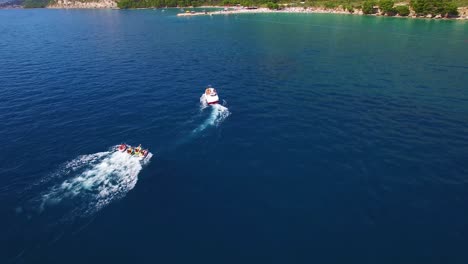 Antena-De-Barco-De-Aventura-Que-Remolca-Cuatro-Cámaras-De-Aire-Para-Una-Aventura-En-Tubing-Frente-A-La-Costa-De-Croacia