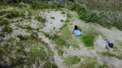 Vista-Aérea-shot-woman-running-at-Quilotoa-Ecuador-caldera-in-the-Andes-Mountains