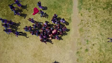 Rising-straight-down-drone-aerial-of-African-children-laughing-and-waving-at-a-school-or-orphanage-in-Kenya