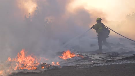 Paletten-Und-Kisten-Brennen-Auf-Dem-Boden,-Während-Feuerwehrleute-Während-Der-Waldbrandkatastrophe-In-Den-Hügeln-In-Der-Nähe-Von-Simi-Valley-In-Südkalifornien-Gegen-Brennende-Strukturen-Kämpfen-1