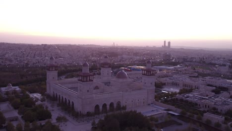 Increíble-Toma-Aérea-Sobre-Una-Mezquita-En-El-Centro-De-Ammán,-Jordania,-Cuando-Las-Luces-Se-Encienden-Al-Anochecer