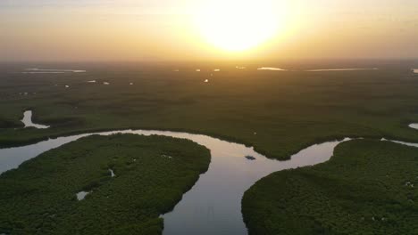 Schöne-Antenne-über-Einem-Kleinen-Boot,-Das-Sich-Entlang-Des-Gambia-Flusses-In-Westafrika-Durch-Mangrovenwälder-Und-Gewundene-Kurven-Bewegt-4